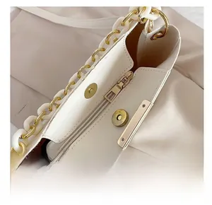 Close-up of secure magnetic snap closure and internal zipper on cream bucket bag