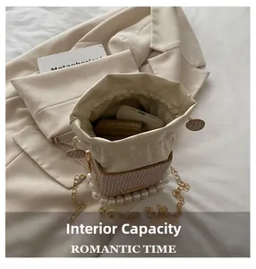 Interior capacity of cream bucket bag showing space for smartphone and small wallet