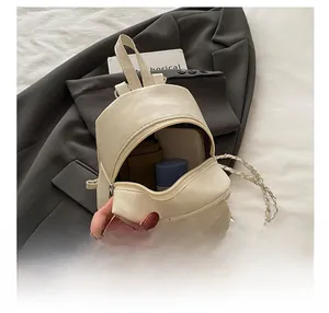 Detail showing internal capacity of mini quilted backpack for phone and makeup
