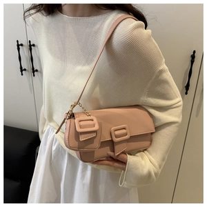 Detail of pink baguette bag with pebbled leather texture and gold chain coin purse accessory