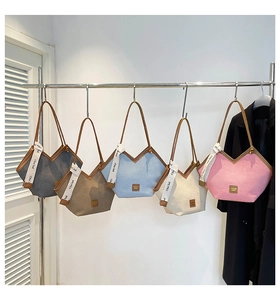 Detailed view of five multi-colored vintage canvas tote bags with leather handles