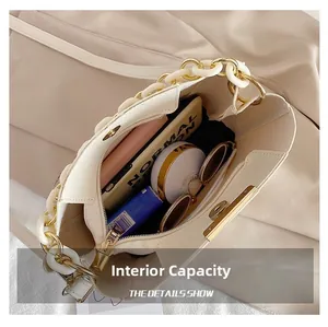 Detail showing internal capacity of ivory bucket bag with crocodile texture and resin chain