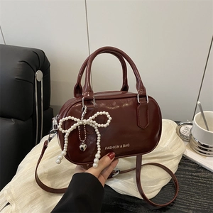 Fashionable wine red glossy bowling bag with pearl bow charm and adjustable strap