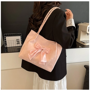 Detailed view of pink velvet tote bag with large bow and braided shoulder straps