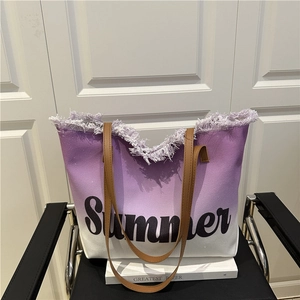 Grand sac de plage dégradé violet avec imprimé Summer et détails effilochés sur une chaise