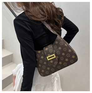Detail of the brown monogram crossbody bag with a gold rectangular metal buckle close-up