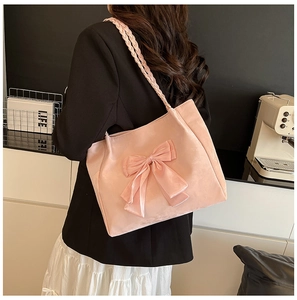 Detailed back view of a pink velvet tote bag featuring a large bow and woven rope straps