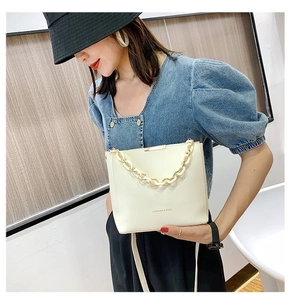 Detail of off-white bucket bag with thick chain and Fashion & Bags text on PU leather