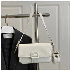 Detail of white lychee leather shoulder bag with matching mini cylindrical charm