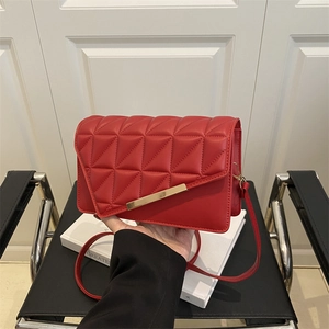 Chic red quilted crossbody bag with gold buckle detail and elegant shoulder strap