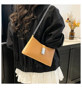 Brown woven texture shoulder bag with silver chain strap shown in a modern lifestyle setting