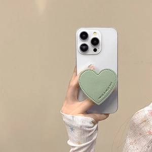 Close-up of heart-shaped green leather phone grip with HAVE A NICE DAY embossing