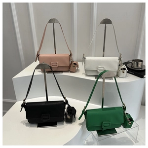 Close-up of stylish faux leather bags with litchi texture and matching mini charms