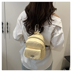 Cream yellow mini quilted backpack shown being worn for a daily casual lifestyle look