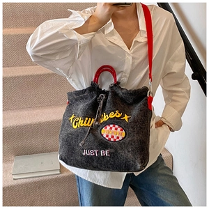 Close-up of grey denim tote bag with red handles and yellow Chillvibes embroidery