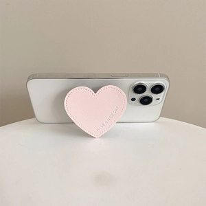 Pink heart-shaped leather cell phone grip holder with Have A Nice Day text on white phone