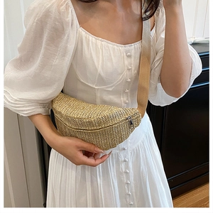Detail of hand-woven straw crossbody chest bag with silver zipper and fabric strap