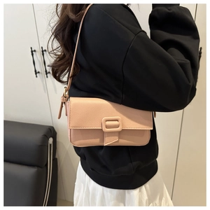 Detail of light pink baguette shoulder bag with pebbled texture and square buckle
