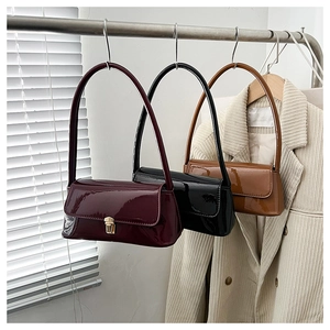 Close-up of glossy retro baguette bags in burgundy, black and caramel colors