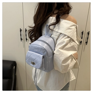 Detail view of the quilted mini bucket backpack with silver twist lock and chain strap