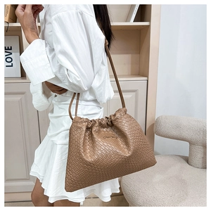 Dettaglio borsa a tracolla in pelle intrecciata kaki con texture plissettata