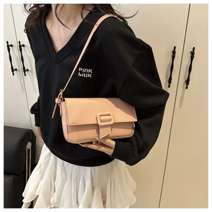 Close-up of pink leather baguette bag with textured finish and buckle on shoulder