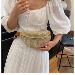 Straw crossbody chest bag with adjustable brown strap worn by model in a cozy interior