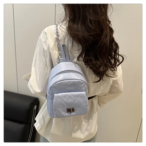Close-up of quilted light blue mini backpack featuring silver chain straps and hardware