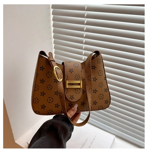 Detail of monogram floral print shoulder bag with gold metal buckle and leather strap