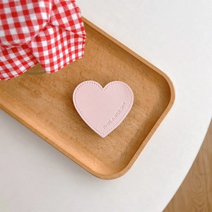 Detail of pink heart leather phone grip with Have a Nice Day embossing and stitching