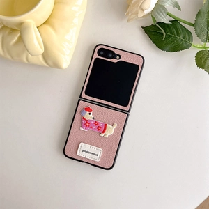 Close-up of pink leather phone case with dachshund embroidery and white goodluck tag