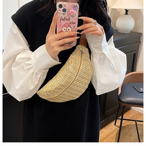On-body shot of a semi-circular straw fanny pack with a metallic zipper and brown strap
