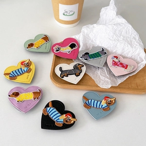 Cute heart-shaped dachshund embroidery phone sockets in nine assorted colors on a wooden tray