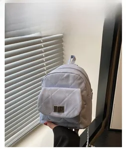 Close-up of light blue quilted mini backpack featuring metal turn-lock and chain straps