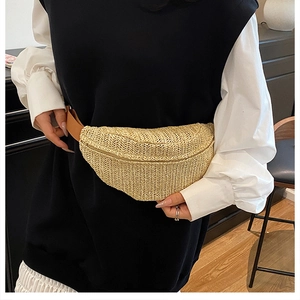Close-up of woven straw waist bag texture and brown strap worn by a female model