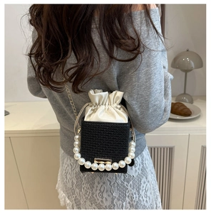 Mini black woven crossbody bag with pearl handle and white satin drawstring detail