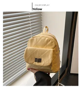 Detail of yellow quilted leather mini backpack with silver metal twist lock and chain strap