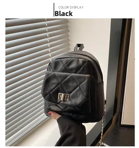 Close-up of black quilted mini backpack with metal twist lock under natural light