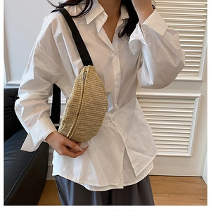 Detail of hand-woven straw crossbody bag with silver zipper and adjustable strap
