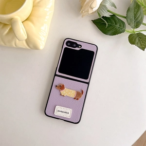 Detail of purple leather phone case featuring a cartoon dachshund embroidery and label