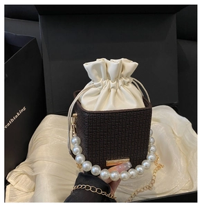Detail of luxury bucket bag with pearl handle and checkered leather texture