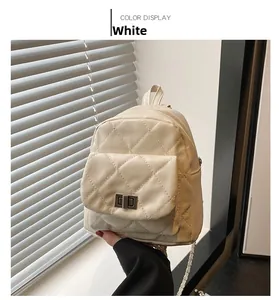 Close-up of white mini quilted backpack featuring a metal twist lock and chain straps