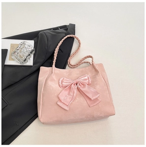 Detail of soft pink faux suede tote bag with large satin bow and woven rope handles