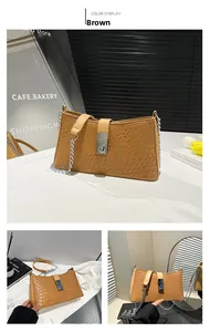 Close-up of brown textured shoulder bag with silver turn-lock and chain strap detail