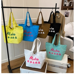 Detailed arrangement of six colorful canvas tote bags with artistic letter printing
