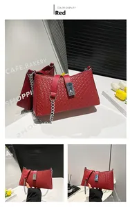 Close-up of red woven texture handbag featuring a silver rectangular buckle and chain strap