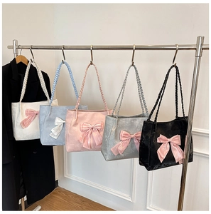 Detail view of large tote bags with decorative bows and woven handles in five soft colors