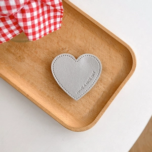 Detail of silver heart phone socket with Have A Nice Day embossing and stitching
