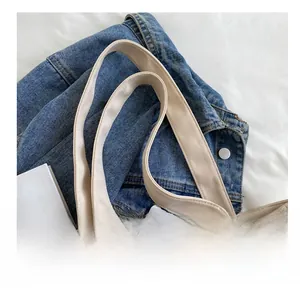 Close-up of durable reinforced shoulder straps on a beige canvas tote bag