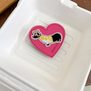 Detail of pink leather heart phone grip with cartoon dog embroidery and 'HAVE A NICE' text